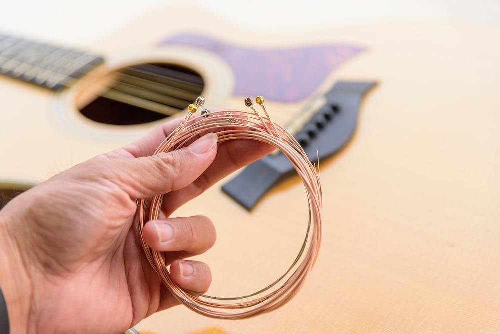 A hand holding a coil of guitar strings