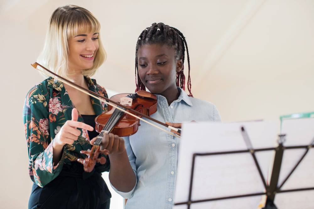 Teen girl receiving private music lessons on her violin 