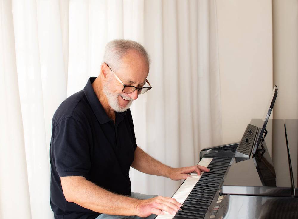A senior man plays the piano 
