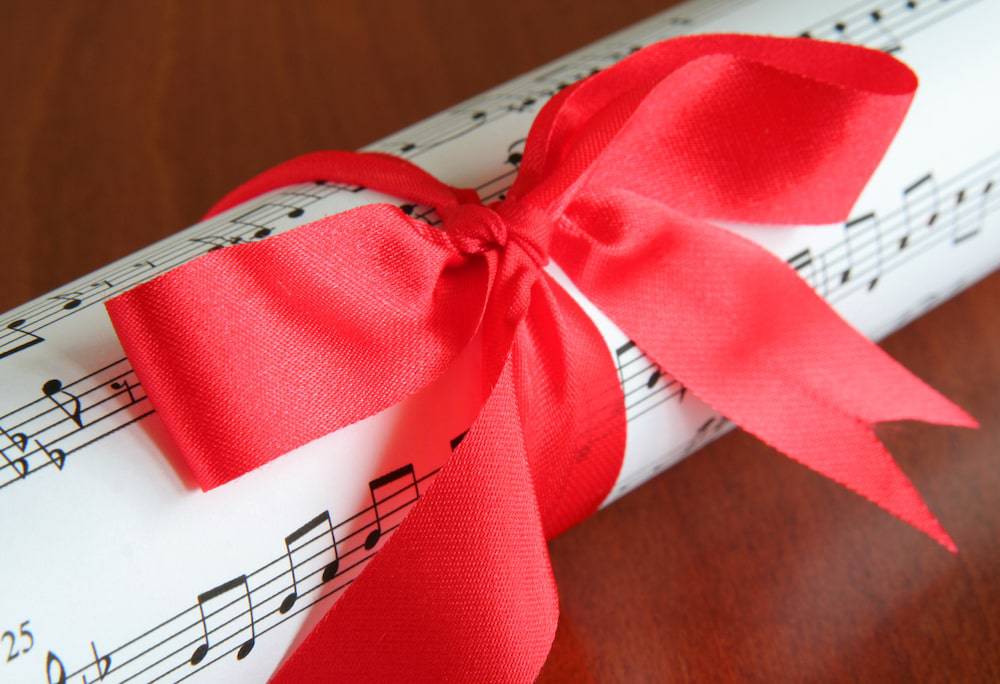 Sheet music wrapped with a red holiday bow