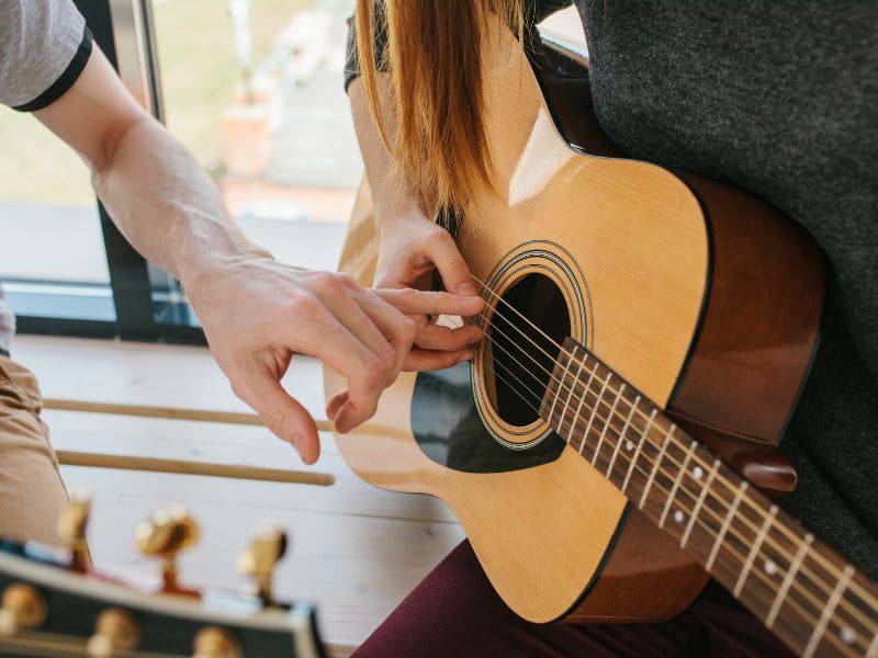 Teen girl taking guitar lesson