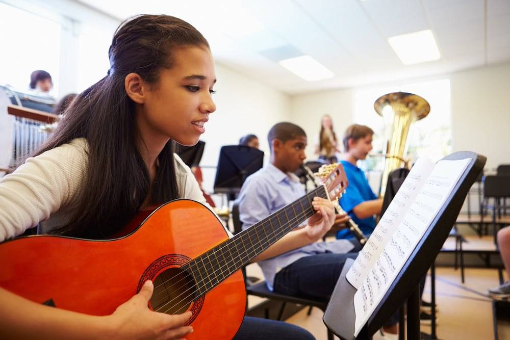 A group of teens practice their instruments at the best music school near me