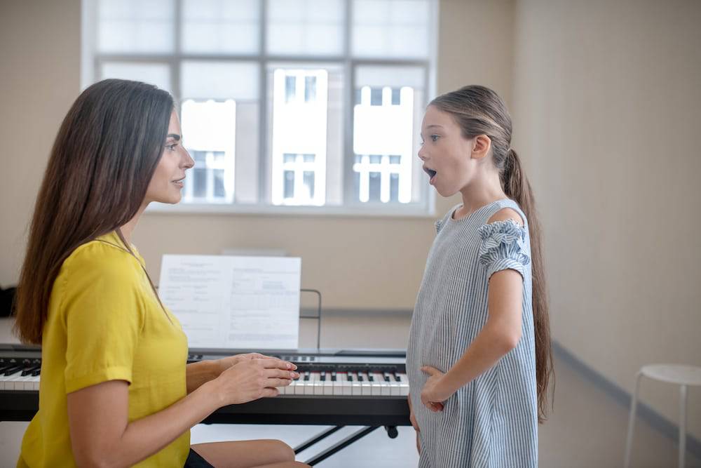 Little girl and vocal coach work together