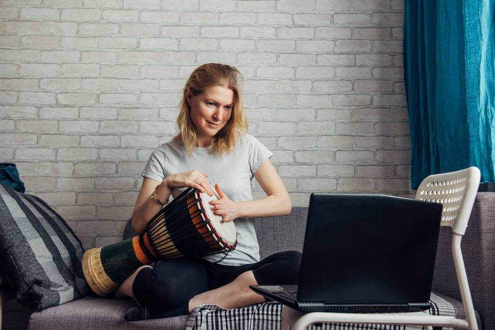 Woman taking online drum lessons for adults