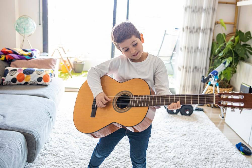 Young boy learning to play the guitar