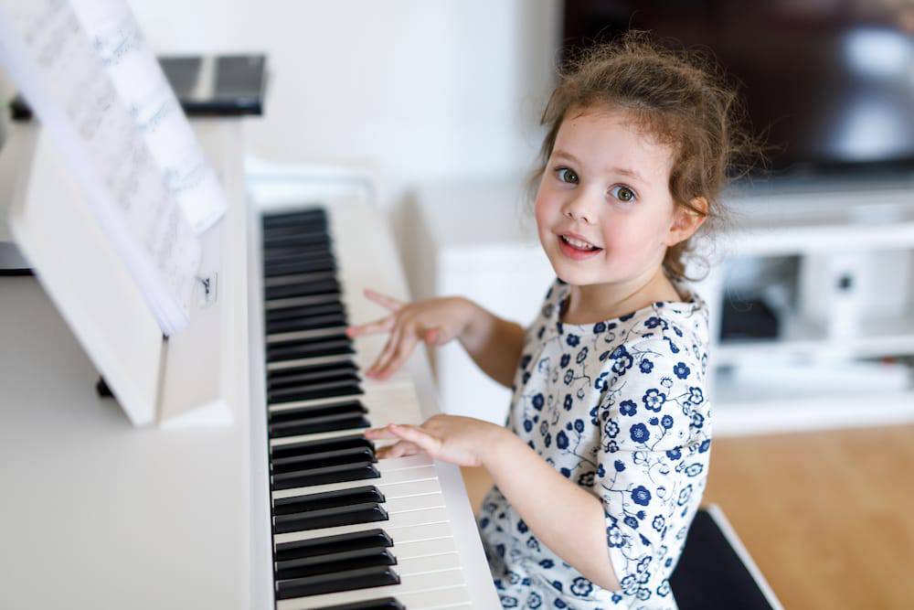 A young happy girl playing the piano