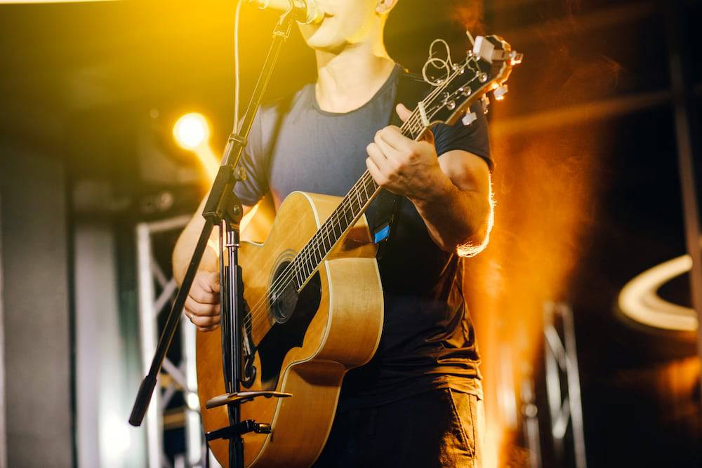 A young man playing guitar on stage