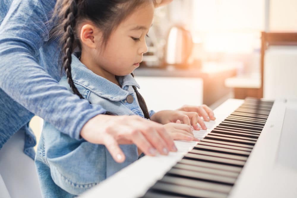 young girl learning to play piano